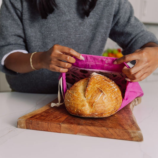 Woman putting bread in artisan bread bag.