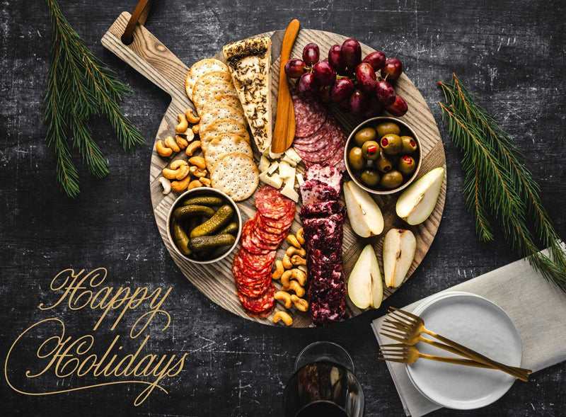 Assorted meats, cheeses, and snacks on a wooden board with 'Happy Holidays' text.
