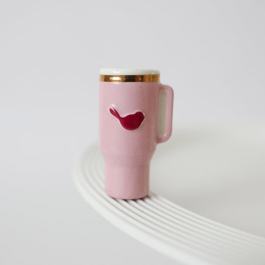 Pink mug with a red lip design on a white surface
