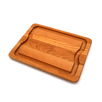A rectangular wooden cutting board with a raised center divider and rounded corners, shown at an angle on a clean white background.
