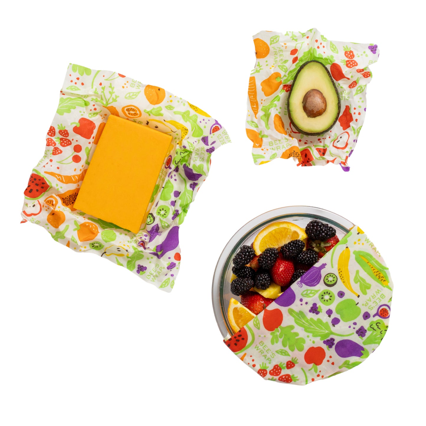 Reusable food wraps with fruits and vegetables pattern containing cheese, avocado, and berries on a white background