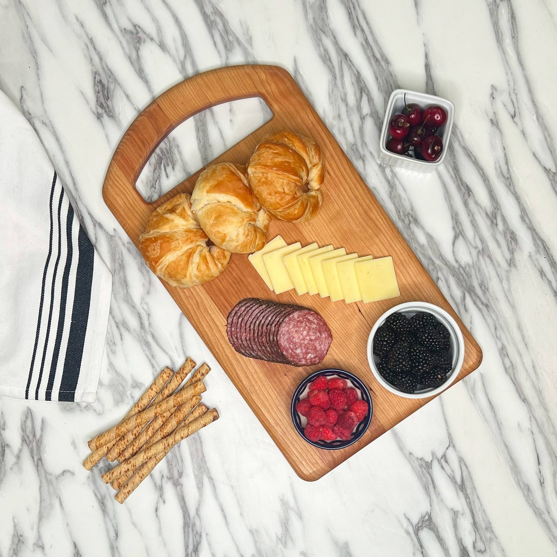 Cherry Serving Prep Board with croissants, charcuterie, berries and cheese
