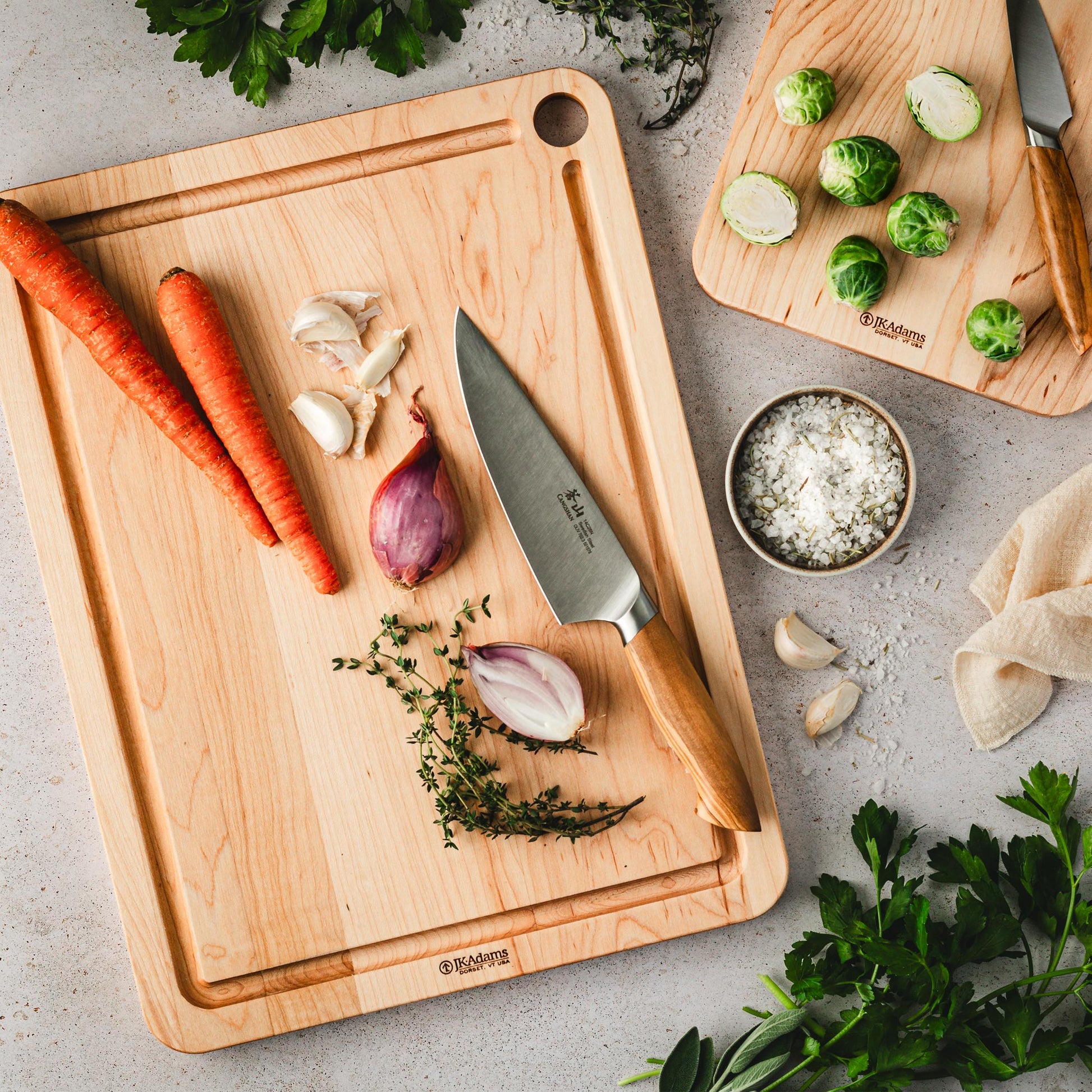 Cangshan Oliv 8 Inch Chefs Knife on a JK Adams Maple Prep board with shallots and carrots