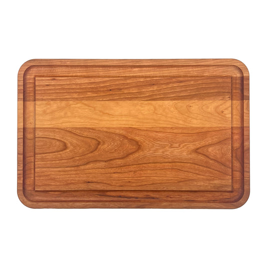 Cherry prep board with a juice groove on a white background.