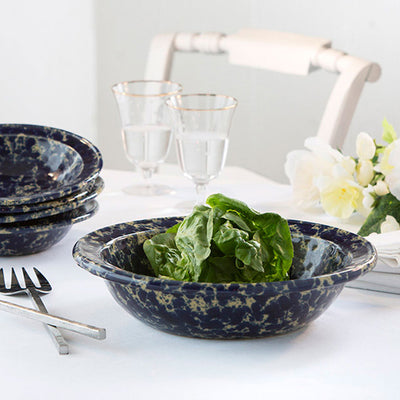 Bennington Potters Blue Agate Rimmed Serving Bowl with lettuce and a stack of blue agate soup/pasta bowls.
