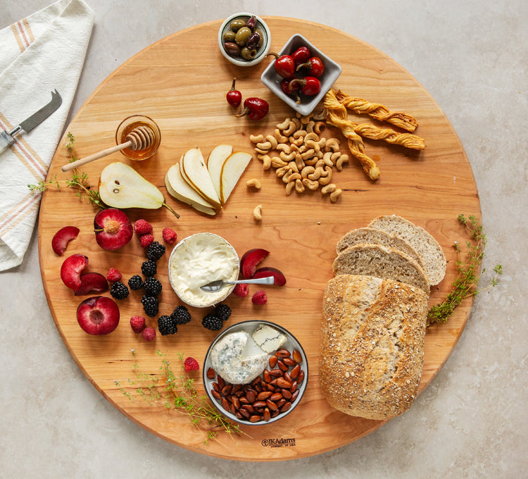 JK Adams cherry large round board with fruit, cheese, nuts and bread