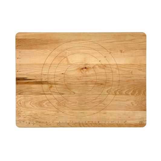 A rectangular wooden cutting board with rounded corners, featuring concentric circle guides and a ruler scale printed on the surface, shown against a plain white background.