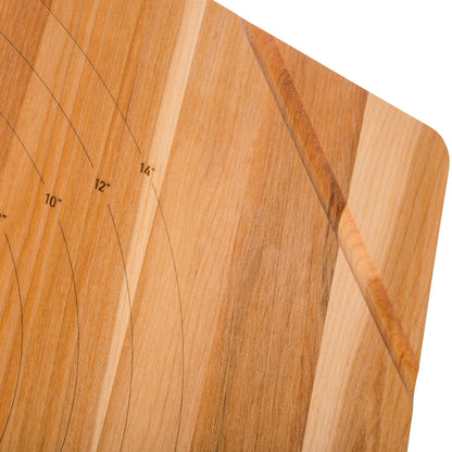 Close-up of a wooden cutting board with visible grain, rounded corners, and engraved measurement markings including 10 inches, 12 inches, and 14 inches on a white background.