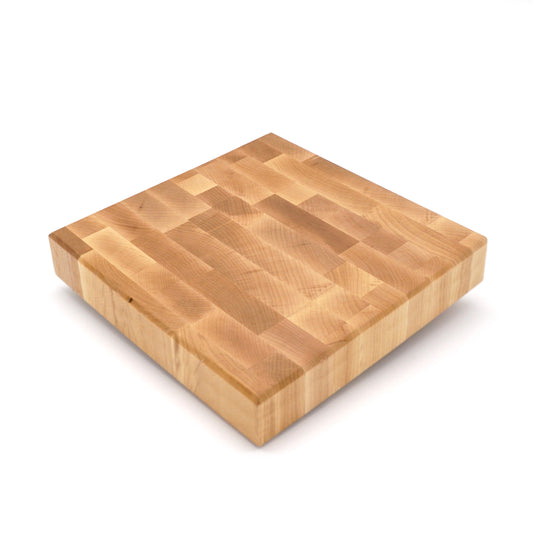 A square wooden butcher block cutting board with a natural light brown wood grain finish, shown from an elevated angle on a white background.