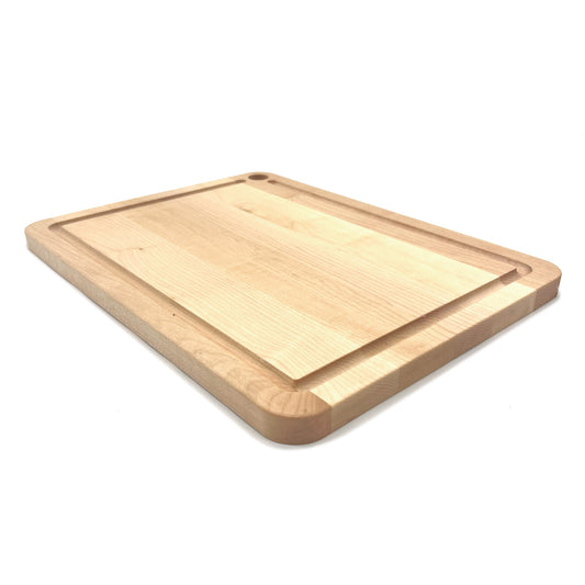Maple cutting board with a small juice groove on a white background.
