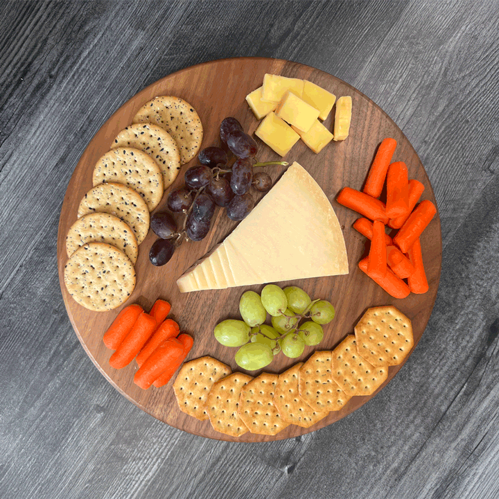 GIF Walnut Lazy Susan turning with cheese, crackers, grapes and carrots on it. 