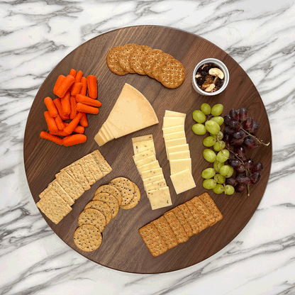 GIF Walnut Lazy Susan spinning on a marble countertop with cracker, cheeses, fruits and veggies.