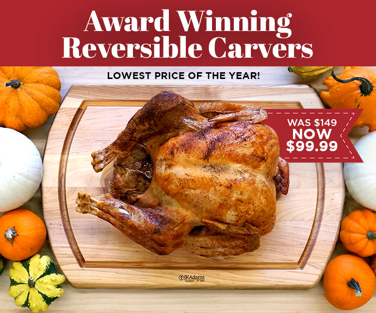 Roasted turkey on a cutting board with pumpkins and onions,